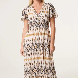 Woman wearing a patterned dress on a white background